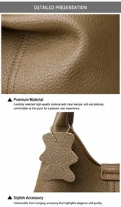 Détails du cuir grainé marron et pendentif ours avec chaîne dorée sur le sac
