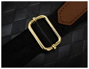 Détail de la boucle en métal doré et couture en cuir marron sur le sac à dos noir