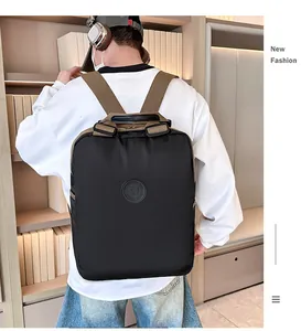 Detail van waterdichte zwarte nylon rugzak met bruine banden en logo op het model getoond