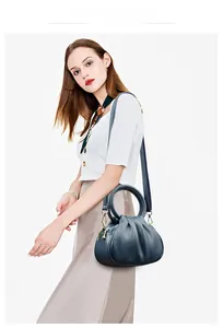 Détail d'un sac nuage en cuir plissé bleu foncé avec poignée ronde et métal doré