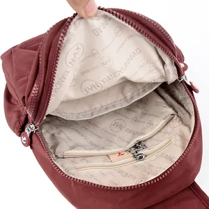 Interior del bolso de nylon granate con compartimentos organizados y forro de marca