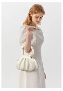 Détail du sac nuage blanc crème avec texture cuir plissé et boucle métallique en forme de D