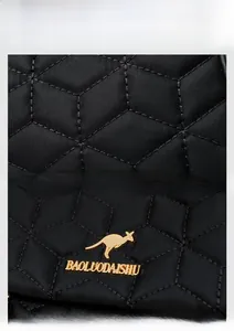 Detail of black quilted fabric with gold kangaroo logo and high-quality hardware textures