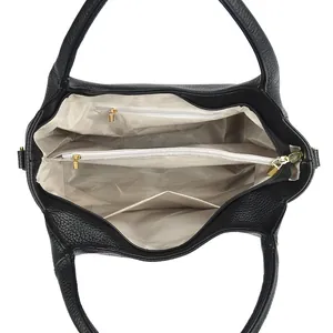 Internal structure of black pebbled leather tote with beige lining and zipper compartments