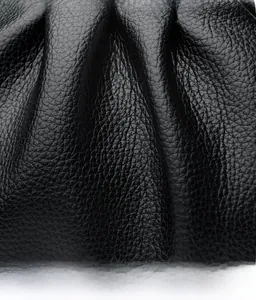 Détail du cuir grainé noir avec un design plissé élégant pour ce sac nuage chic