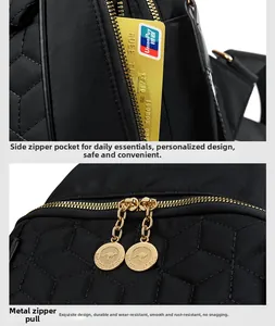 Detail of the side zipper pocket and golden kangaroo logo hardware on the quilted backpack