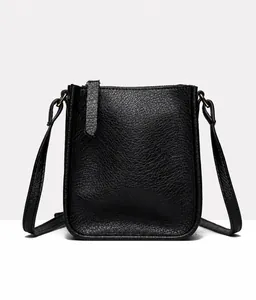 Front view detail of a black litchi pattern leather phone bag with a long zipper puller