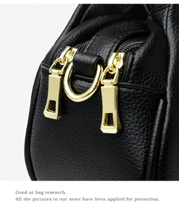 Détail du sac en cuir litchi noir avec élégantes fermetures éclair doubles dorées