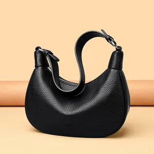 Elegante bolso de media luna en cuero granulado negro con cremallera y correa de hombro