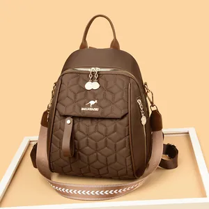 Brown quilted backpack with hexagonal patterns and a patterned woven shoulder strap