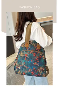 Detail of vintage floral canvas backpack featuring durable straps and metal zipper pullers