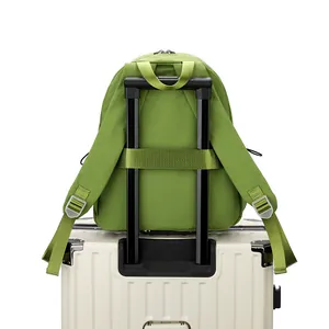 Waterbestendige groene nylon rugzak met bagageriem bevestigd aan een koffer