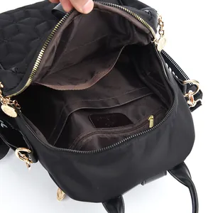 Black quilted backpack with interior storage pockets and brand logo lining detail