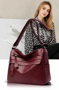 Detail view of burgundy leather shoulder bag showing lychee grain and woven textures