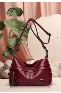Macro detail of wine red leather hobo bag with fringe tassel and silver kangaroo logo