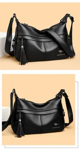 Close-up of black lychee grain leather shoulder bag with metal kangaroo logo and tassels