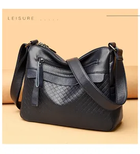 Detail of dark blue leather bag with rhombus pattern, quilted textures and metal zippers