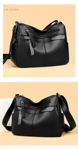 Close-up of black leather crossbody bag with dual zippers and litchi texture finish