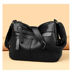 Detail of black pebbled leather crossbody bag with multiple functional zip pockets