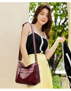 Detailed view of the burgundy rhombus textured crossbody bag with a front zipper