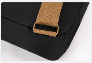 Detail van zwarte nylon stof met bruine riem en antieke bronzen metalen gesp