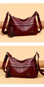 Close-up of burgundy lychee leather shoulder bag with fringe tassel and logo detail