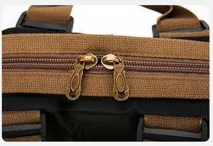 Detail van de bronzen ritsen en bruine canvas banden op een zwarte nylon rugzak voor reizen
