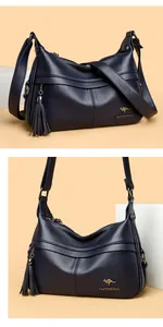 Detail of dark blue lychee leather handbag featuring a metal kangaroo logo and stylish tassel