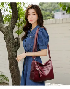 Close-up of wine red quilted shoulder bag with woven texture and adjustable strap