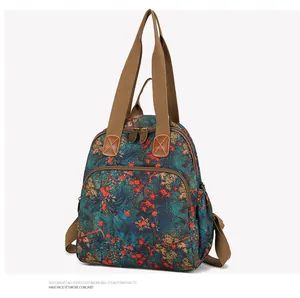 Detail of vintage floral backpack with orange maple leaf pattern and sturdy brown handles