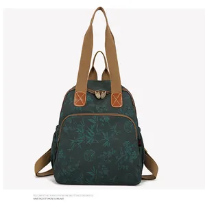 Detail of floral vintage backpack showing durable dark cyan fabric and brown handle straps