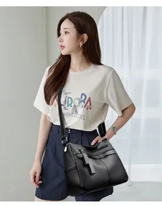 Close-up of black lychee grain leather crossbody bag with tassel and multi-pocket design