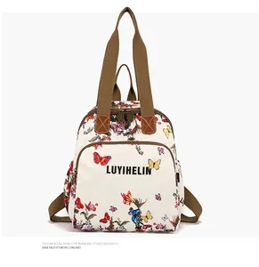 Detail of floral butterfly print backpack with sturdy brown straps and multi-pocket layout