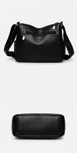 Detail view of the black grained leather bag showing back zipper pocket and flat base stitching