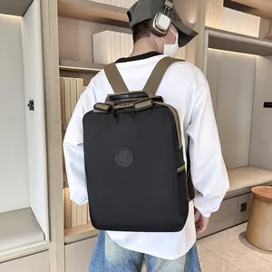 Zwarte nylon rugzak met bruine riemen op een model, waterbestendig en retro design