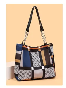 Detail of diamond lattice tote bag showing colorful geometric panels and silver chain strap
