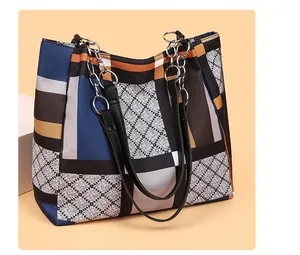 Close-up of geometric patchwork tote bag with chain strap and diamond lattice patterns