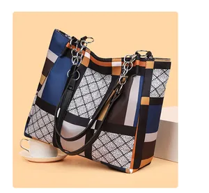 Close-up of geometric patchwork tote bag with diamond lattice pattern and chain strap