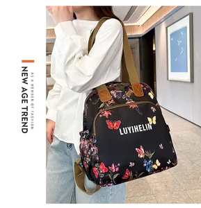 Detail of floral butterfly print on black nylon backpack with durable brown webbing straps