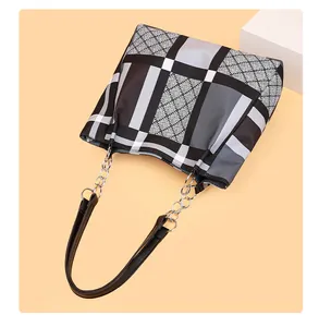 Detail of diamond lattice pattern tote with metallic glitter and chain strap accent