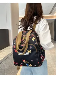 Floral print backpack with butterfly patterns on shoulder of a model in a bright hallway