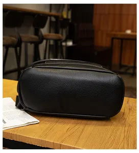 Μακροσκοπική λεπτομέρεια μαύρης δερμάτινης τσάντας με λευκές ραφές σε ξύλο