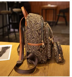 Detalle de mochila marrón vintage estampada con cremalleras doradas en una cafetería