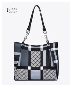 Detail of diamond quilted tote bag with silver chain straps and black handle