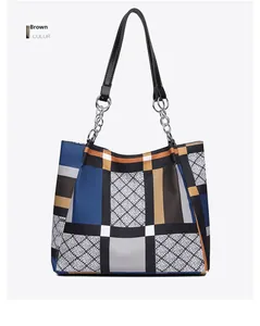 Detail of geometric pattern tote bag with silver chain straps and brown patchwork finish