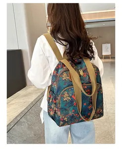 Detail view of floral vintage backpack with durable khaki straps and multi-pocket design