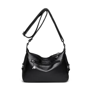Black litchi grain leather crescent bag with multiple zipper pockets and kangaroo charm