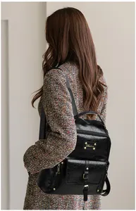 Détail du sac à dos vintage en cuir ciré noir avec rivets dorés porté par un mannequin