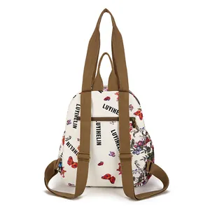 Vintage floral backpack with butterfly prints and brown straps on a white background