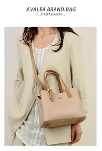 Borsa a mano chic in pelle beige a grana litchi abbinata a un blazer bianco panna